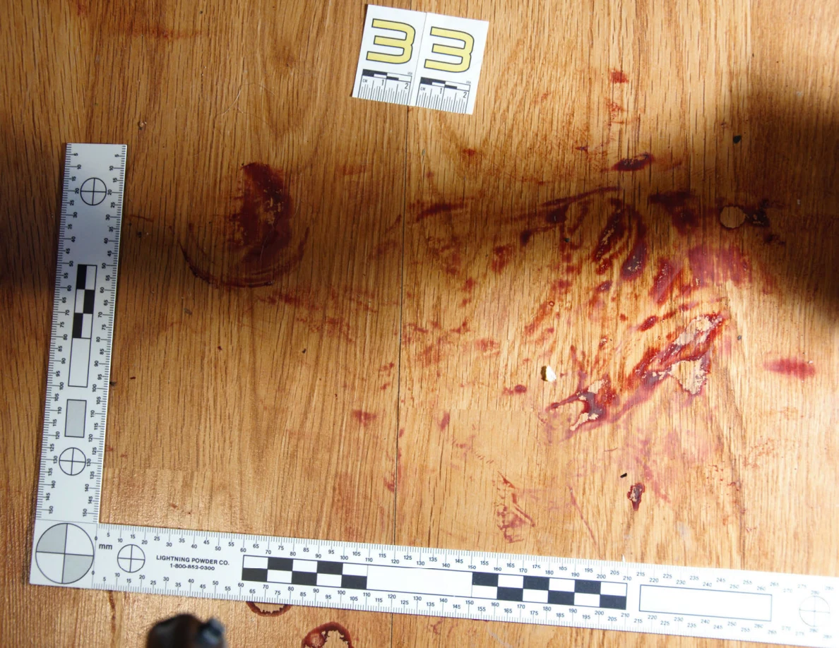 Reddish circular and smeared floor marks beside scale label 33 and measuring rulers.
