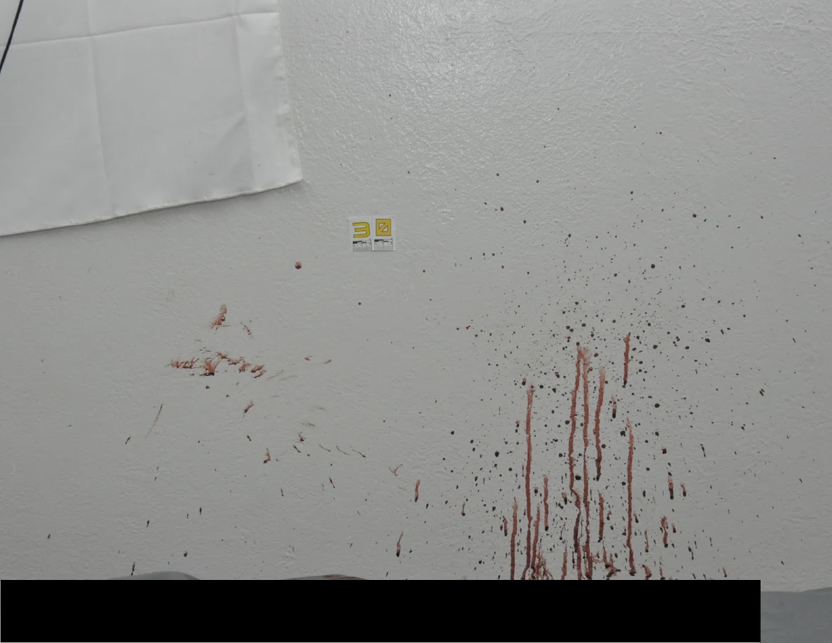 Reddish wall streaks beside a yellow scale label and a black redaction.