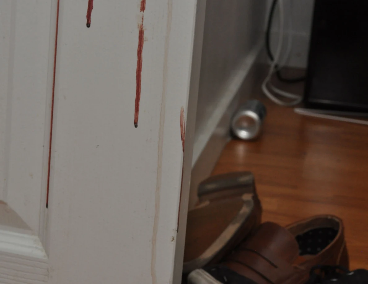 Close view of long reddish streaks on a white door.