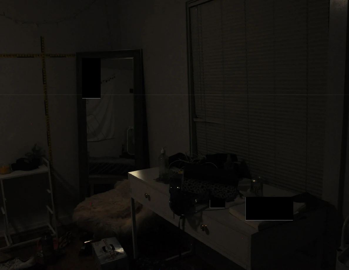 Dim view of a desk and tall mirror beneath closed blinds.