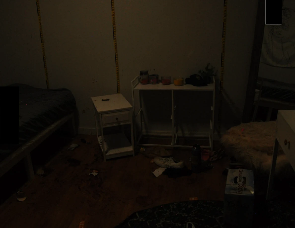 Dim view of bedside furniture below yellow wall scales.