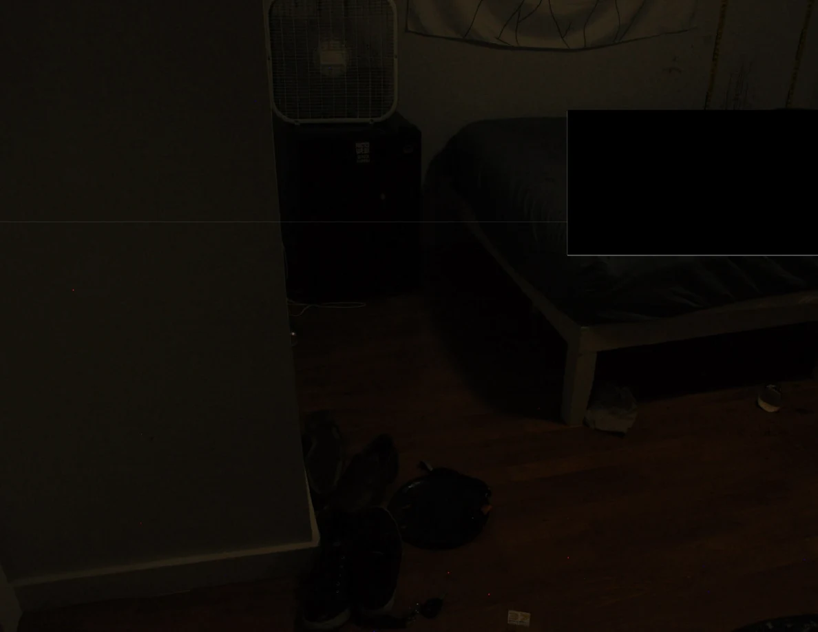 Dim view of a partly redacted bed, mini fridge and footwear.