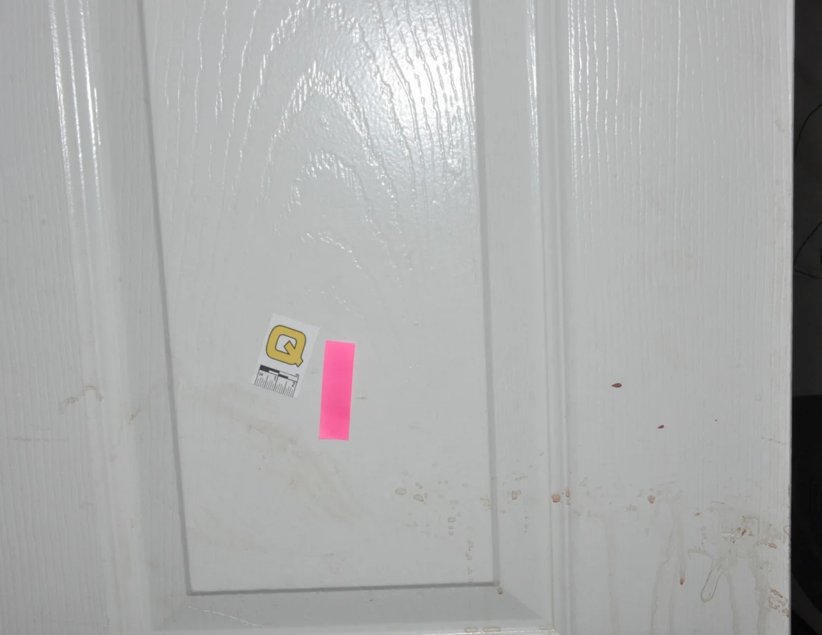 Scale label Q beside pink tape on a white door.