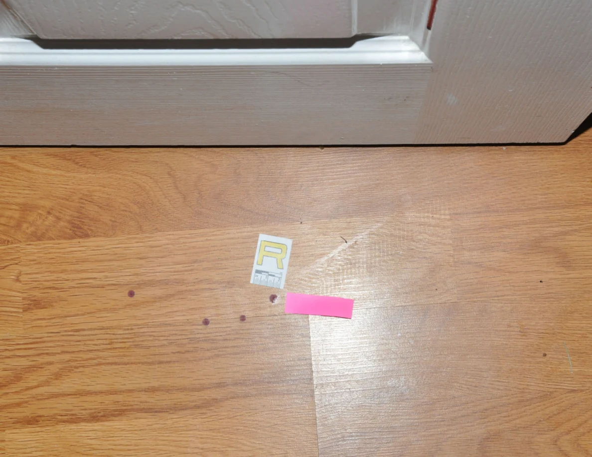 Small reddish floor spots beside scale label R and pink tape.