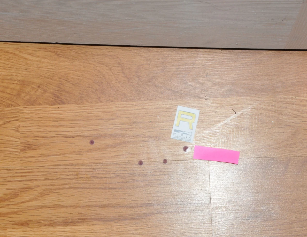 Small reddish floor spots beside scale label R and pink tape.