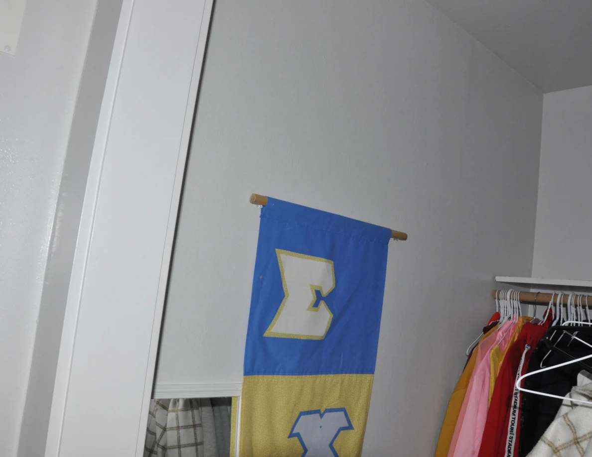 Upper blue-and-yellow banner beside closet clothing rails.