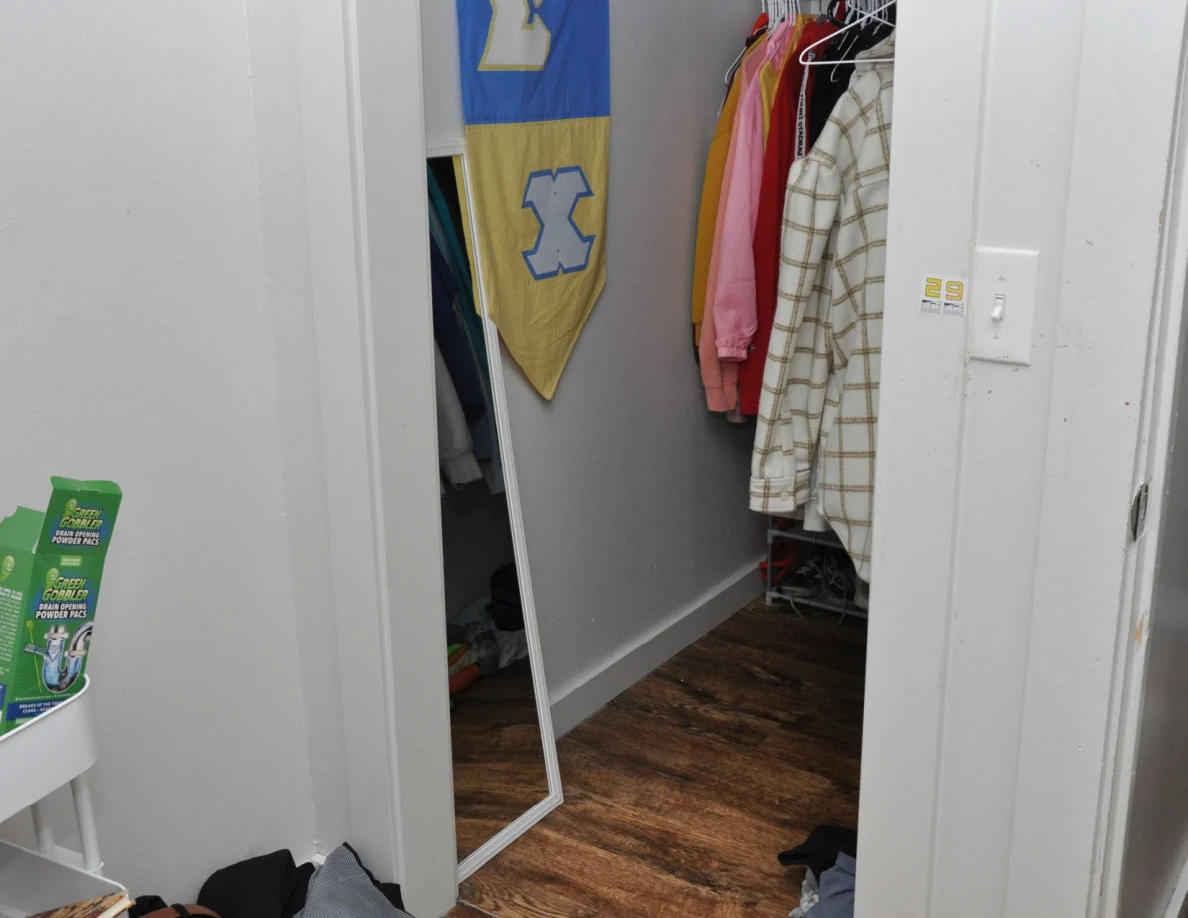 Closet doorway with a mirror, banner and wall switch.