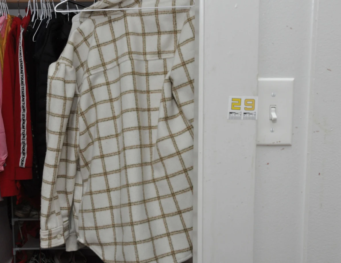 Hanging plaid garment beside scale label 29 and a wall switch.