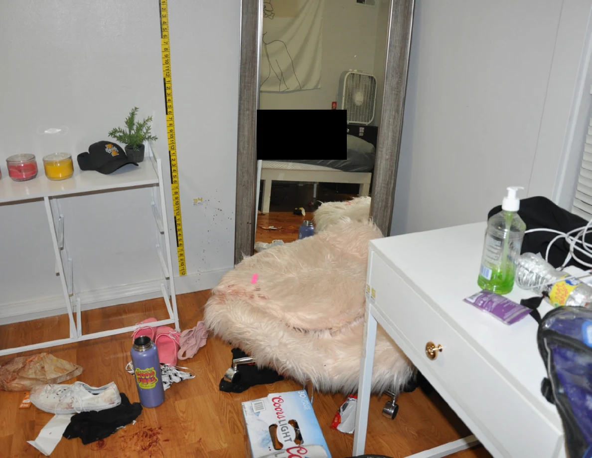 Fluffy chair with pink tape beside a mirror, white desk and wall measuring tape.