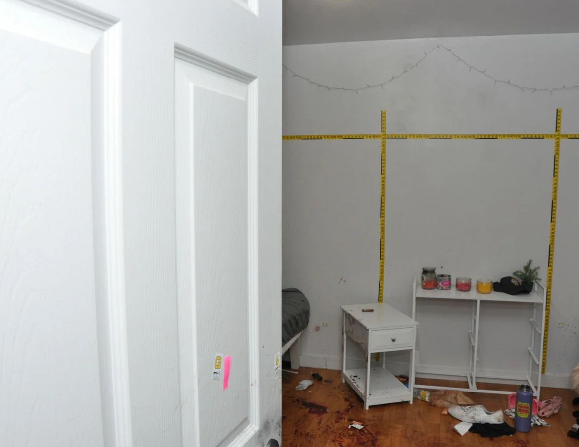 Bedroom doorway view of yellow wall scales above white bedside furniture.