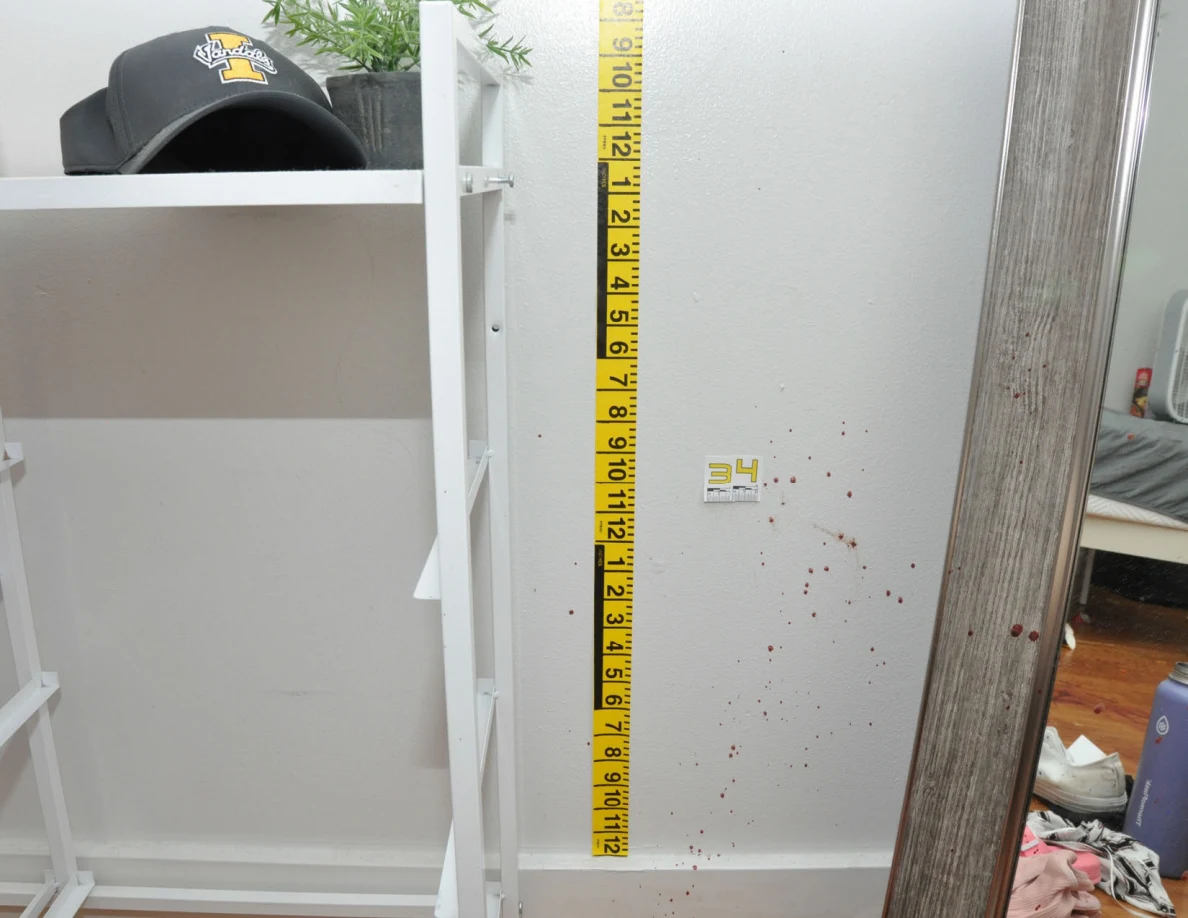 Yellow measuring tape beside reddish wall spots and scale label 34 near a mirror.