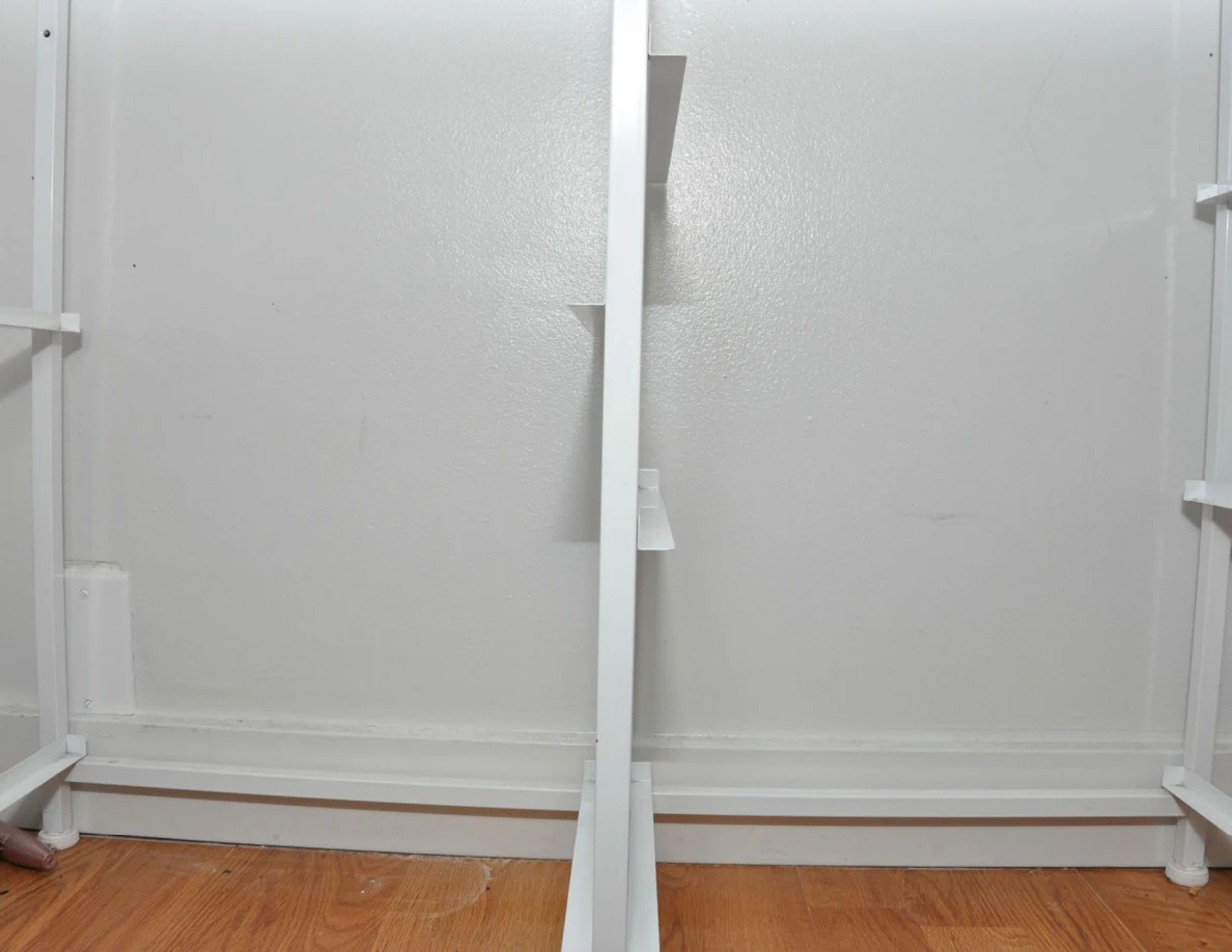 Lower white cabinet frame against a pale wall above wood-pattern flooring.
