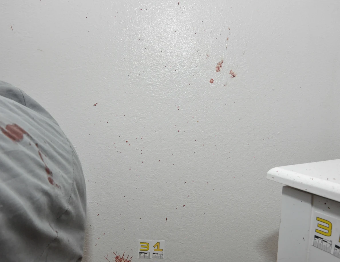 Reddish wall spots between a bed and white cabinet.