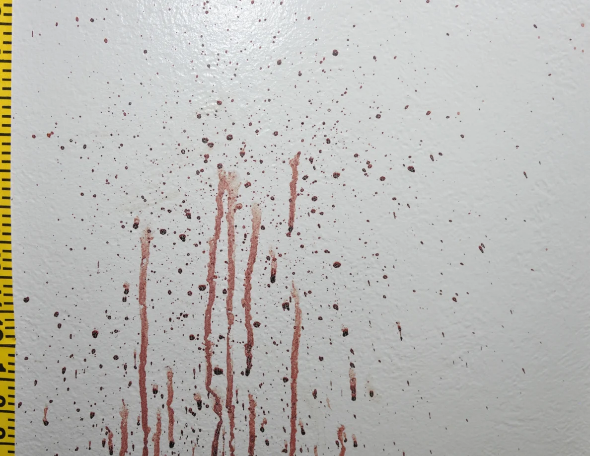 Reddish wall streaks beside a yellow measuring tape.