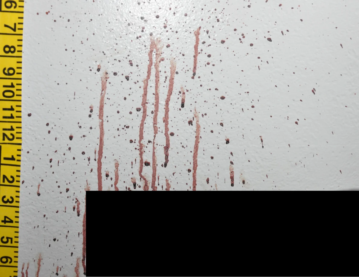 Reddish wall streaks beside measuring tape and a black redaction.