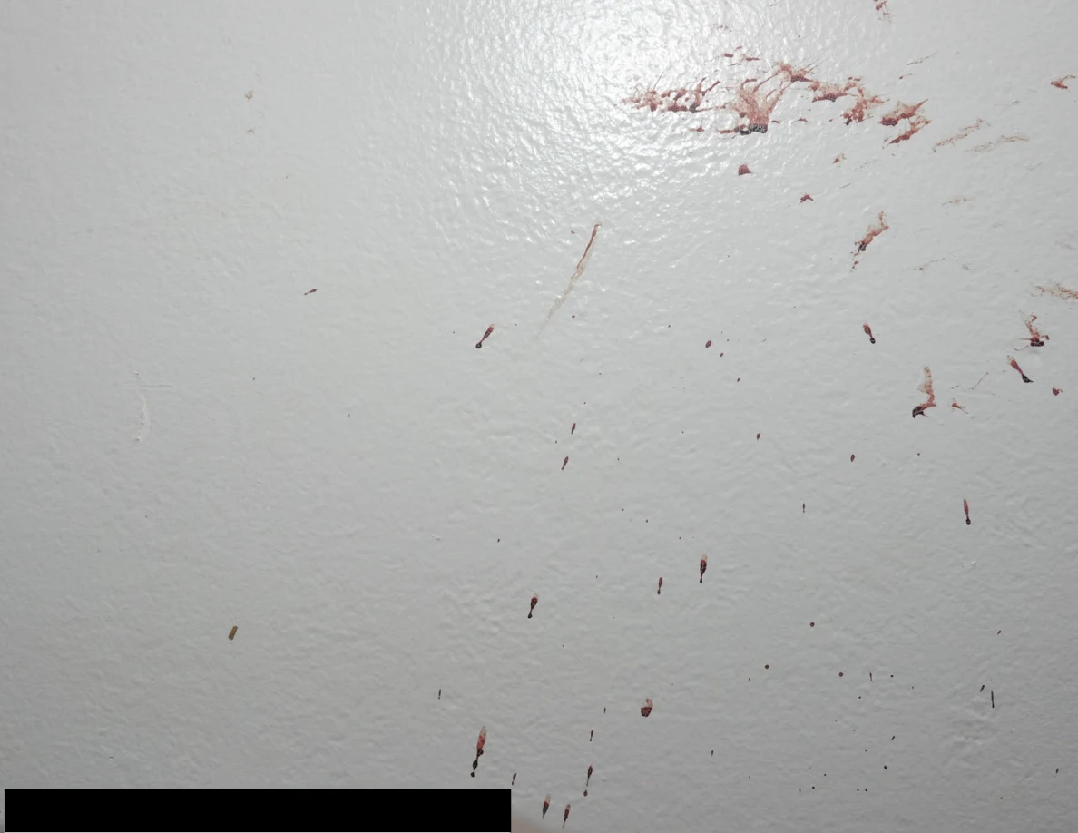 Reddish wall streaks above a black redaction.