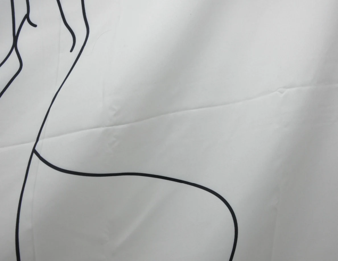 Close view of a fabric wall hanging with black line art.