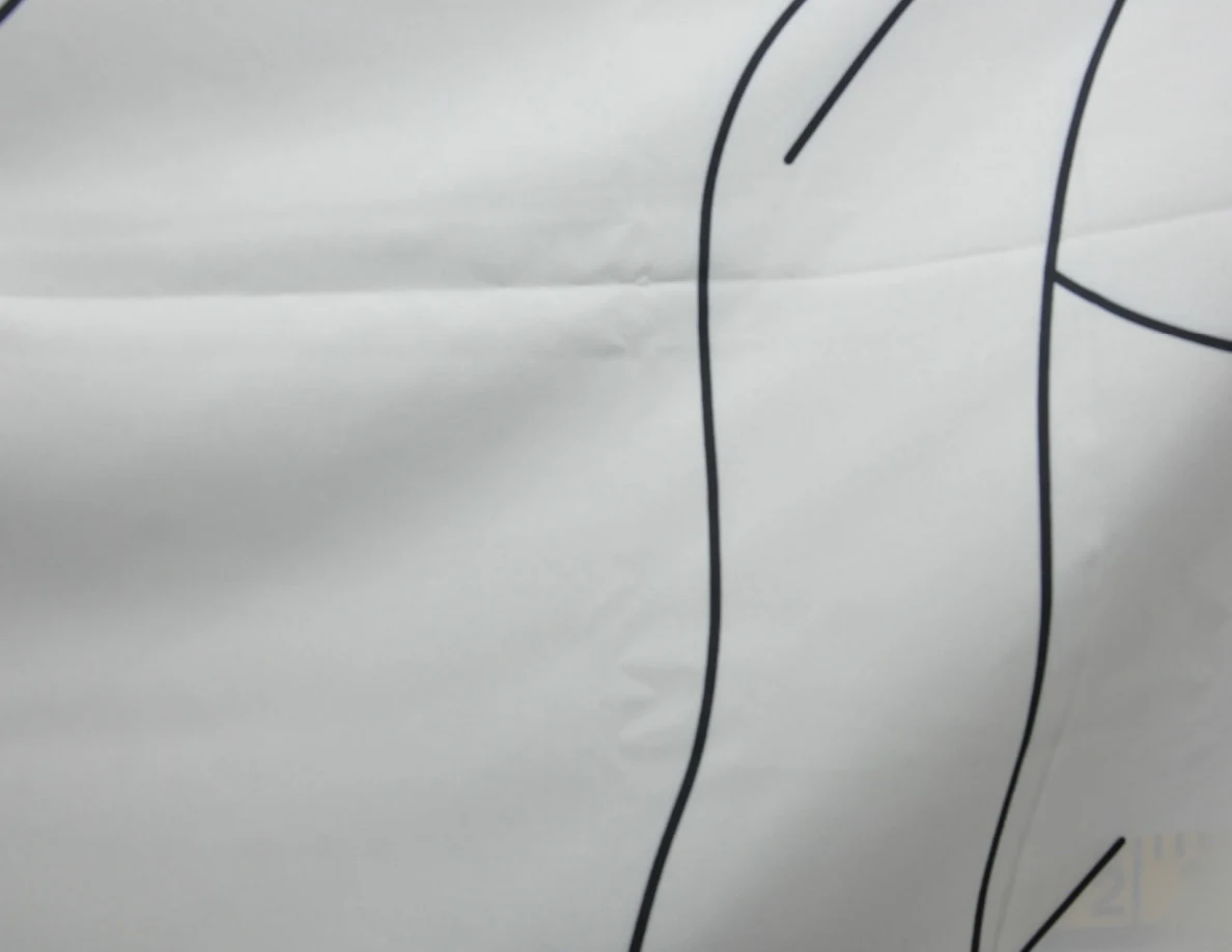 Close view of black line art on a fabric wall hanging.