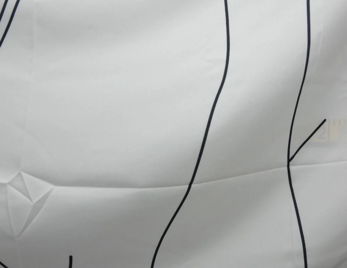 Close view of black line art on a fabric wall hanging.