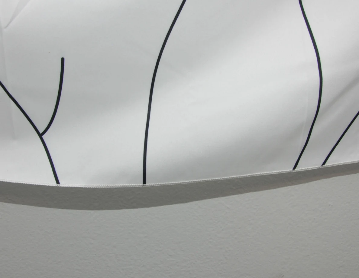 Lower edge of a fabric hanging with black line art.