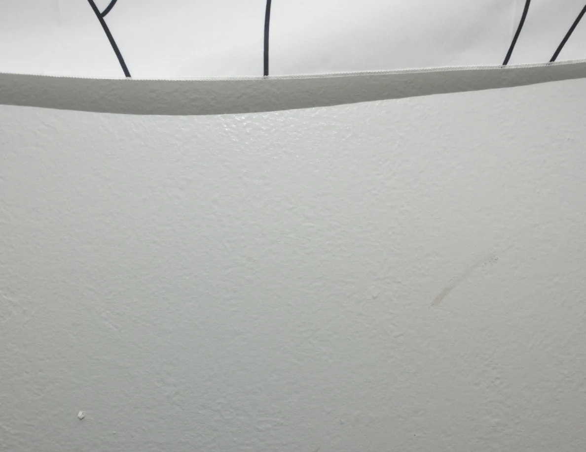 Faint wall marks below a fabric hanging.