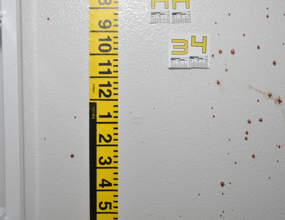 Close view of wall spots beside label AA34 and measuring tape.