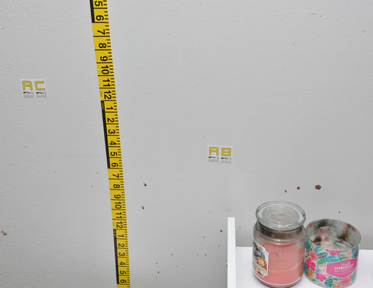 Wall labels AC and AB with measuring tape above candles.