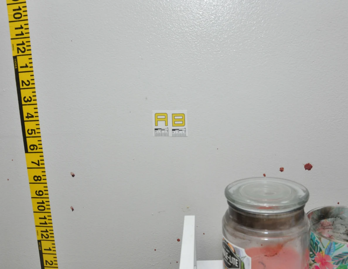 Wall label AB beside measuring tape.