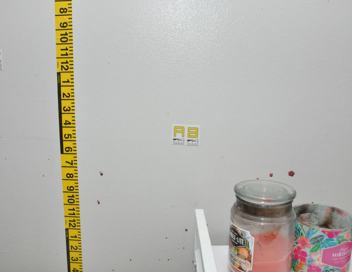 Wall label AB and measuring tape above candles.