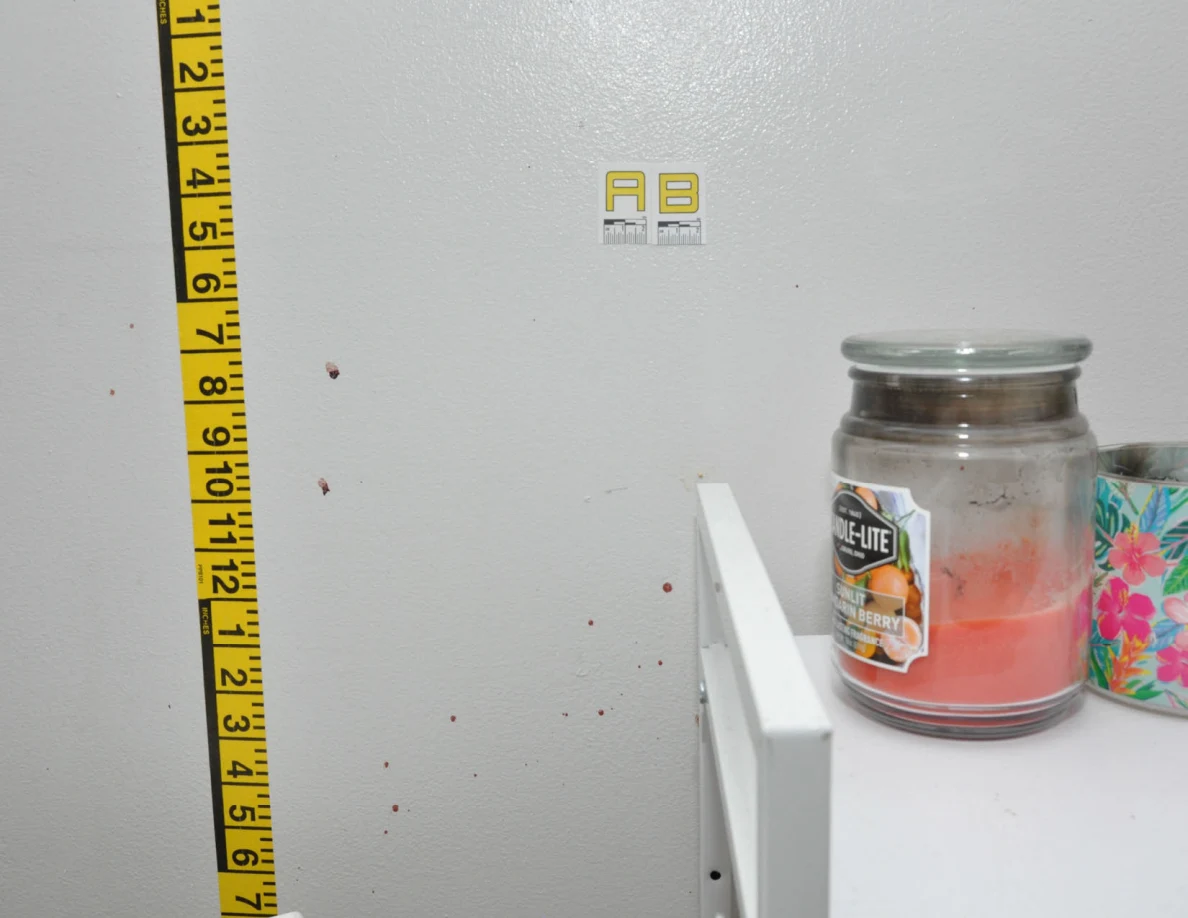 Wall label AB and measuring tape beside a cabinet.