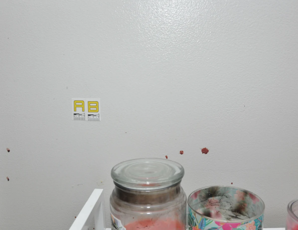 Reddish wall spots beside label AB above candles.