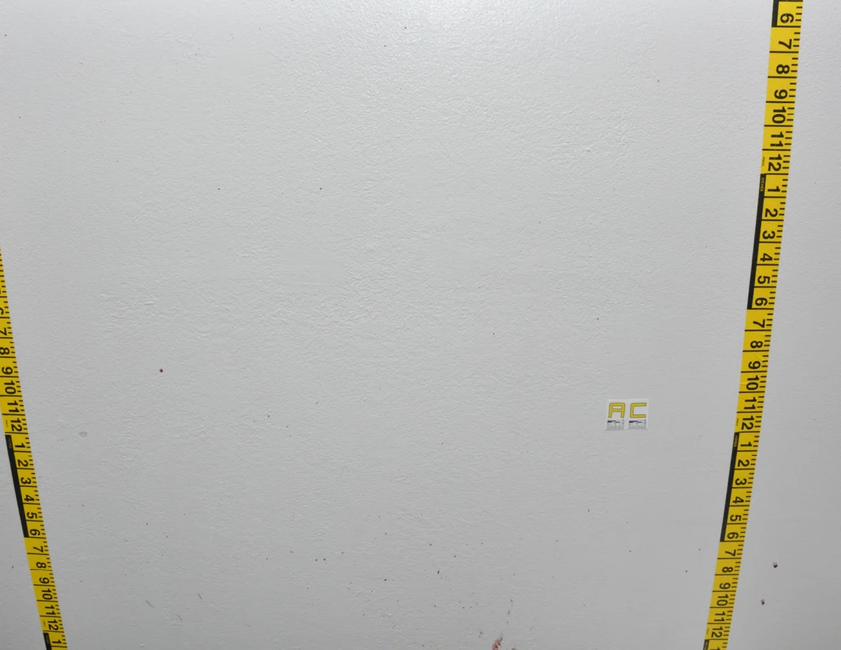 Wall label AC between vertical measuring tapes.