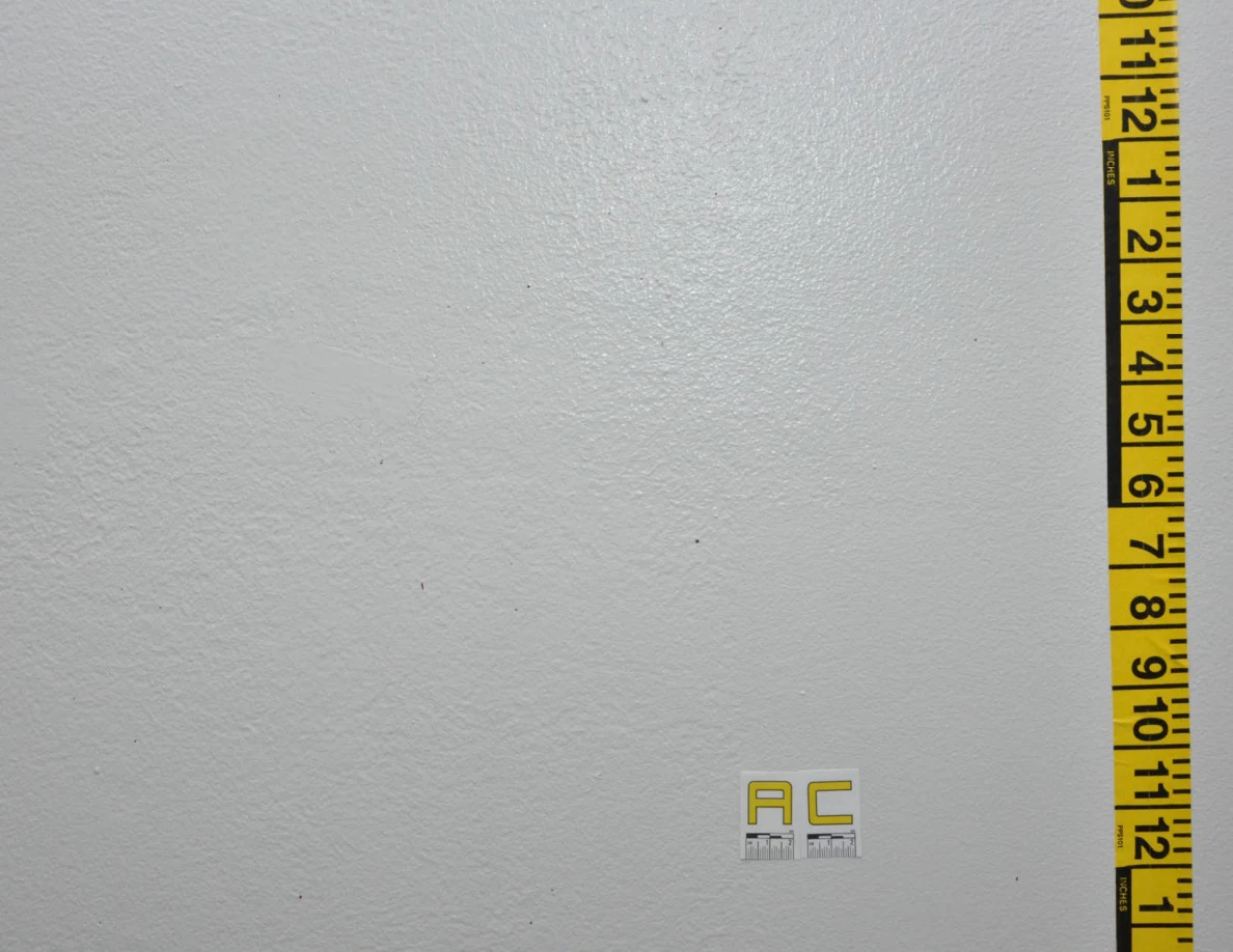 Faint wall spots beside label AC and vertical measuring tape.