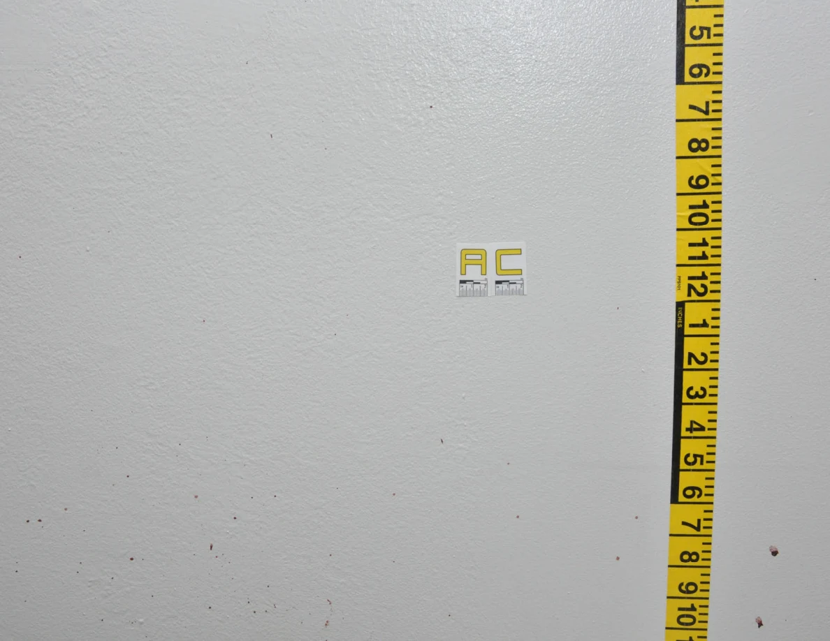 Faint wall spots beside label AC and vertical measuring tape.