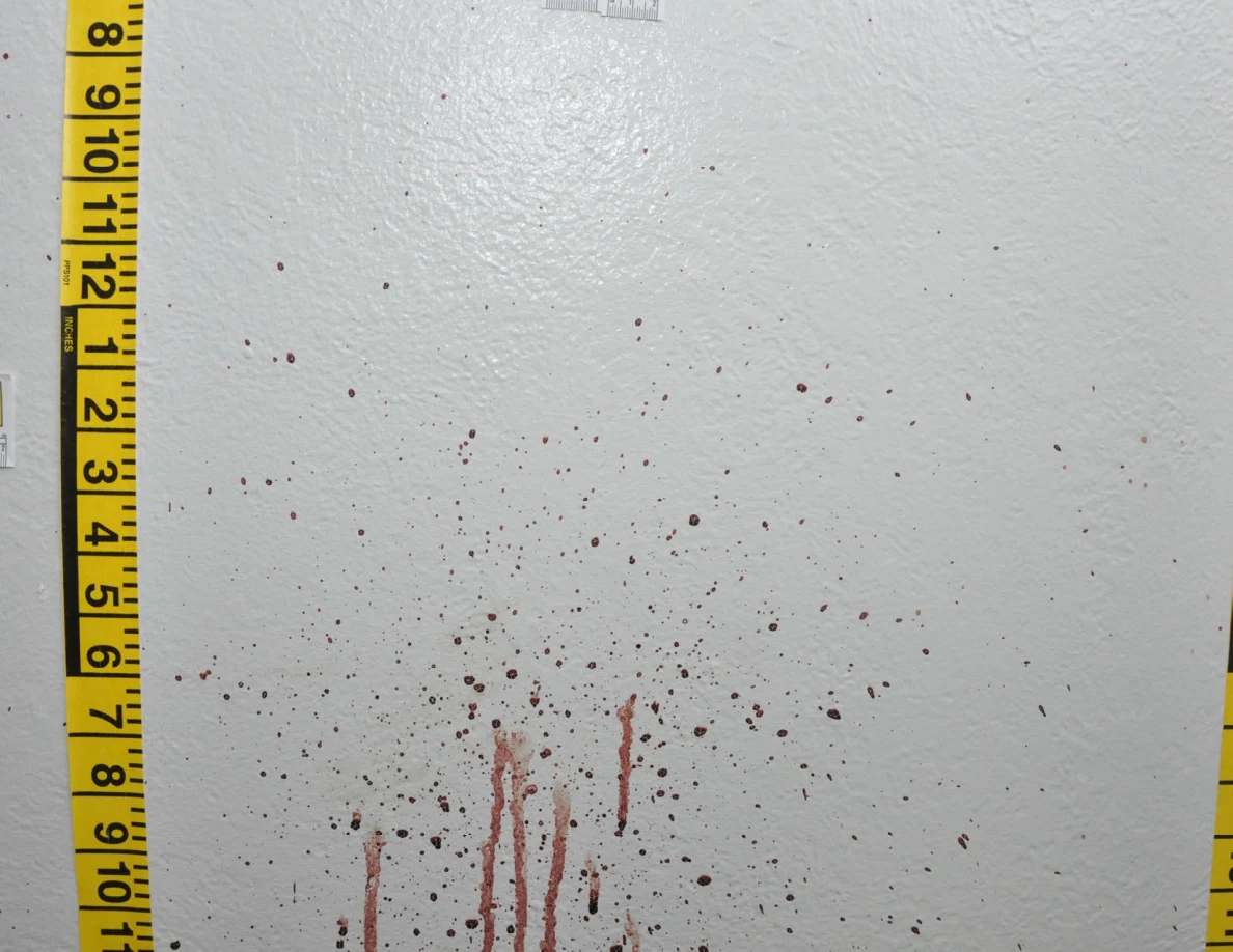 Reddish wall spots and long vertical streaks beside yellow measuring tape.