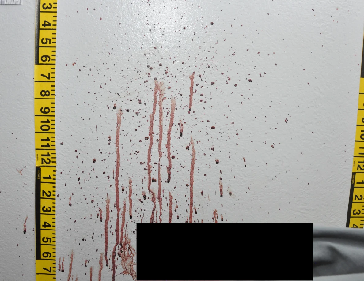 Reddish wall spots and long streaks between measuring tapes above a black redaction.