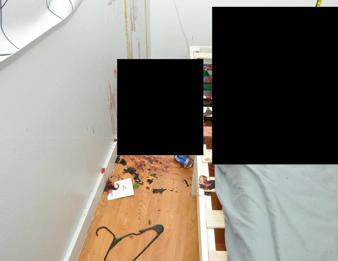 Clothes hanger, blue can and scattered dark fragments on wood floor beside a bed and black redactions.