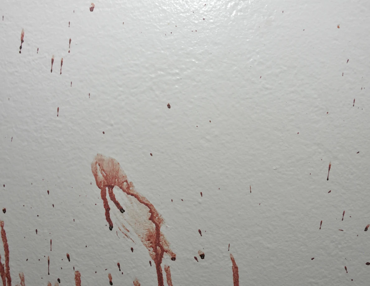 Reddish smear with downward streaks on a white wall.