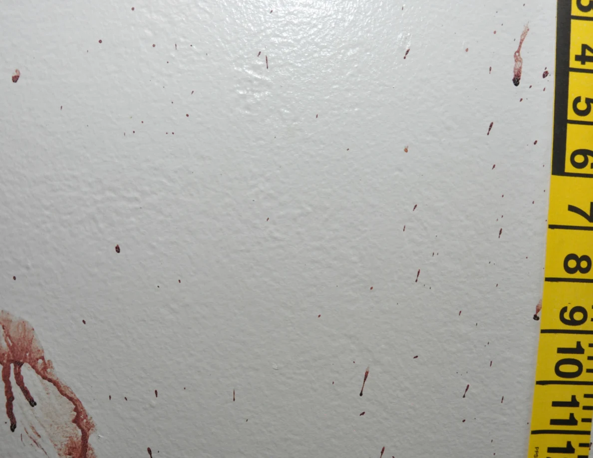 Small reddish wall streaks beside yellow measuring tape.