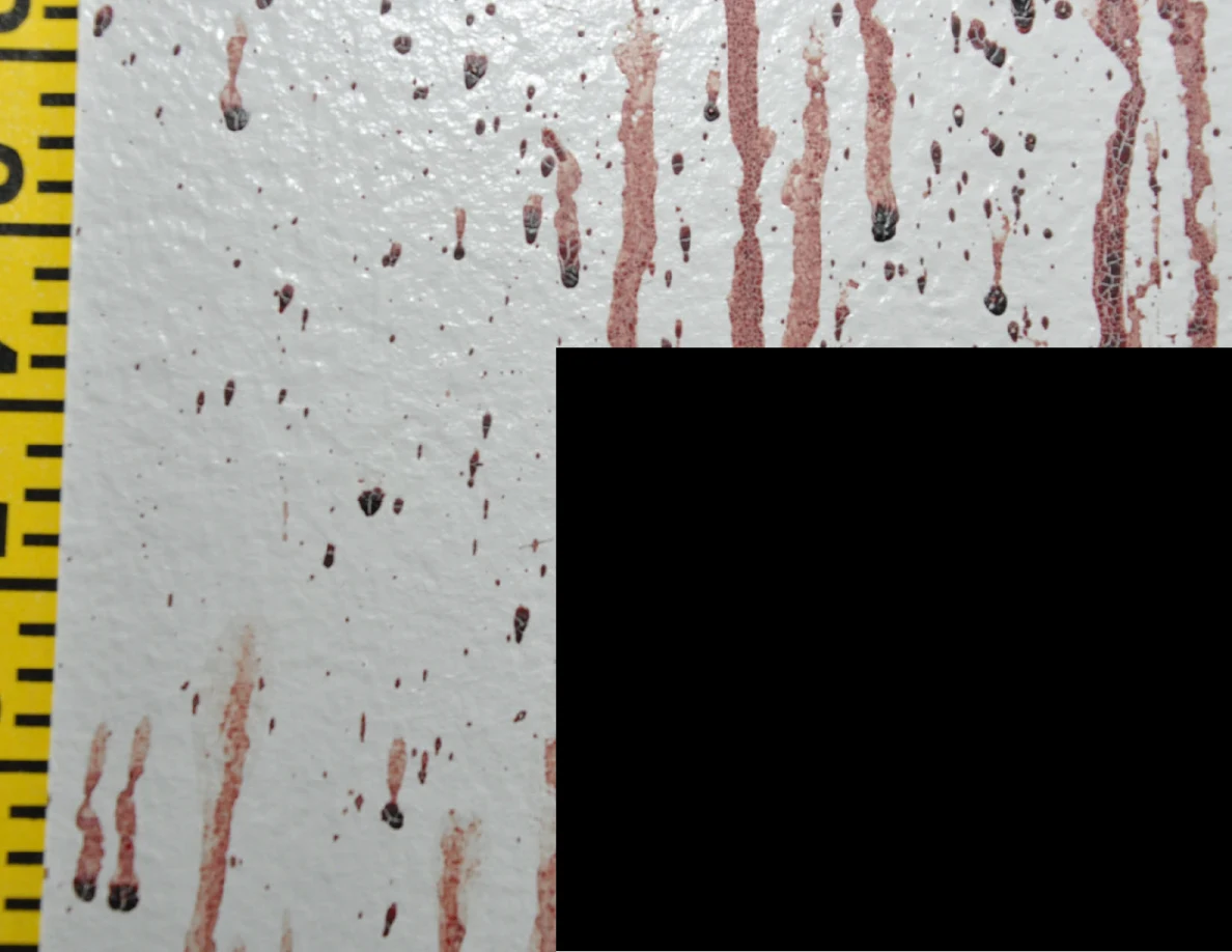 Reddish wall streaks beside measuring tape and a black redaction.