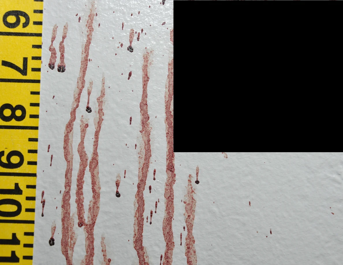 Reddish wall streaks beside measuring tape and a black redaction.
