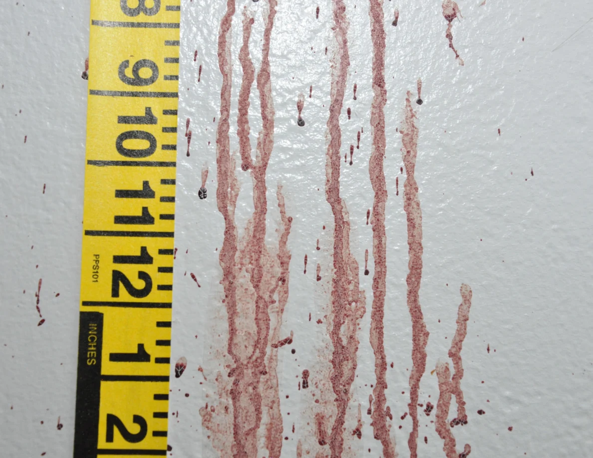 Long reddish wall streaks beside vertical yellow measuring tape.