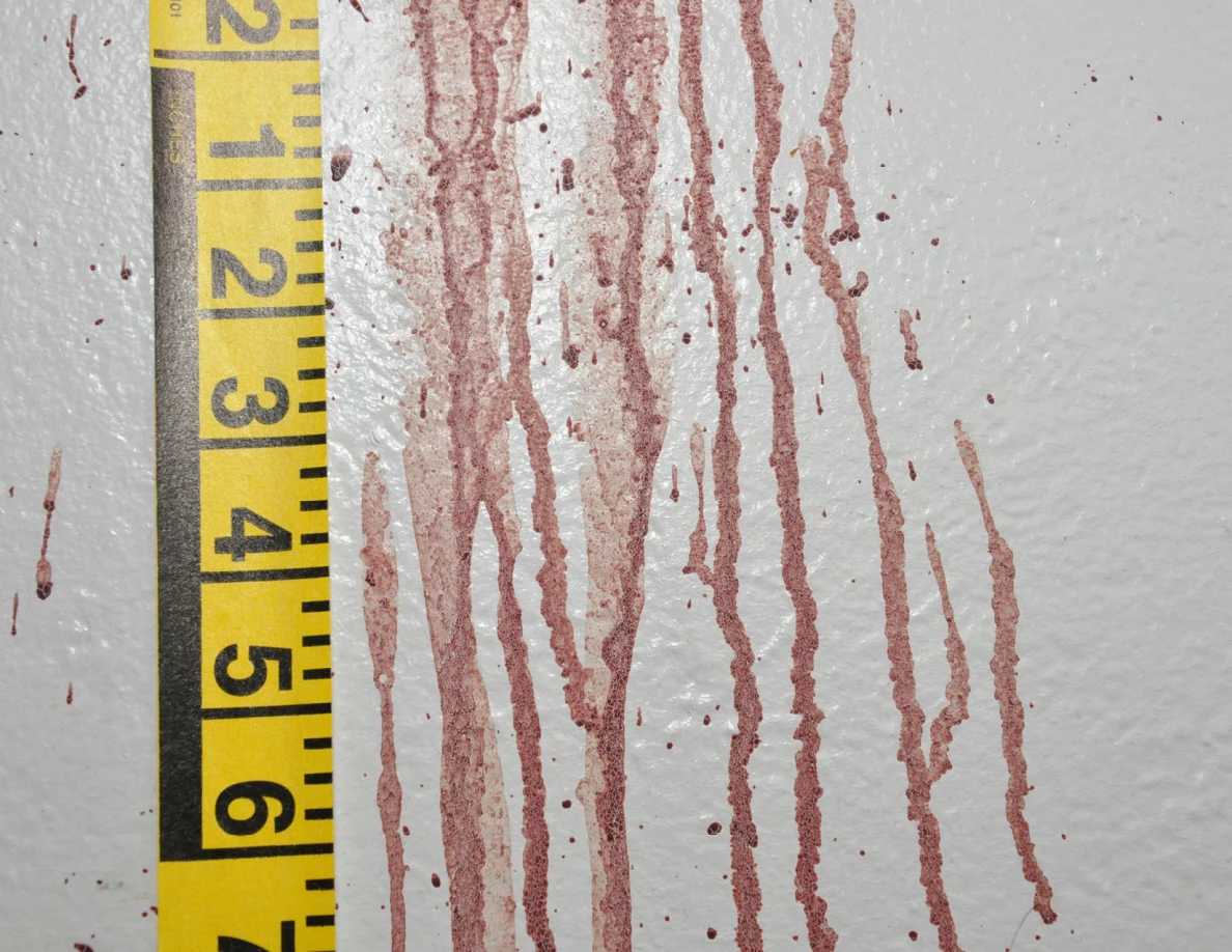 Long reddish wall streaks beside vertical yellow measuring tape.