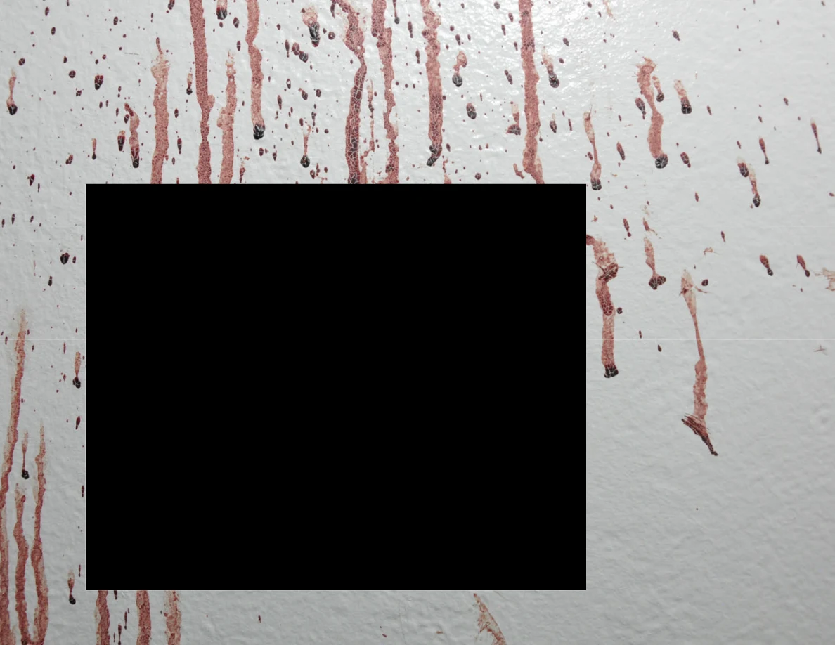 Long reddish wall streaks around a black redaction.