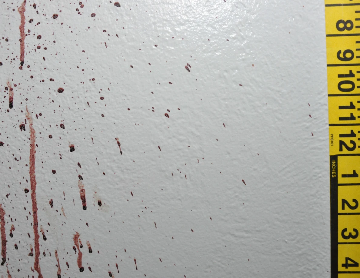 Reddish wall drops and long streaks beside measuring tape.