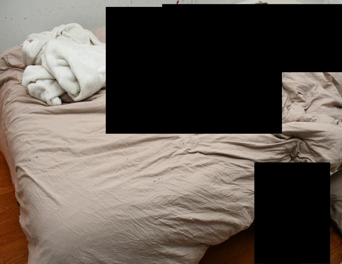 Rumpled pale bedding and white blanket around black redactions.
