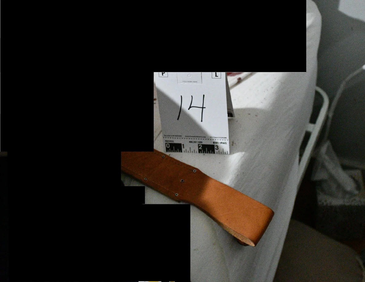 Brown leather sheath beside evidence marker 14 on a white mattress, with black redactions.